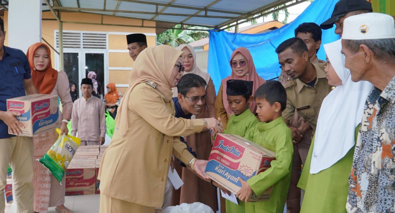 Wabup Kampar Misharti menyerahkan santunan kepada anak yatim di Desa Baru, Kecamatan Siak Hulu, Kabupaten Kampar, Selasa (25/2/2025)