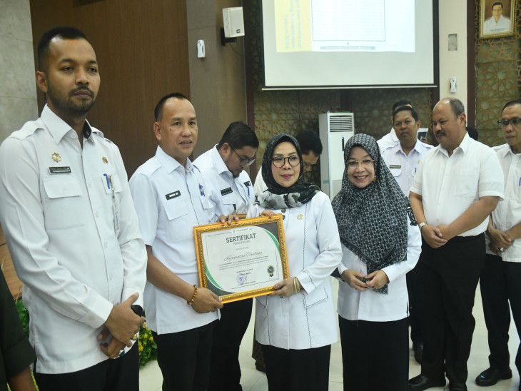 Wakil Bupati Kampar Dr Hj Misharti Sag Msi didamping Kepala Bapenda menyerahkan penghargaan saat sosialisasi penyesuaian NJOPPBB-P2 di Aula Kantor Bupati Kampar, Rabu (16/4/2025).( Diskominfo)